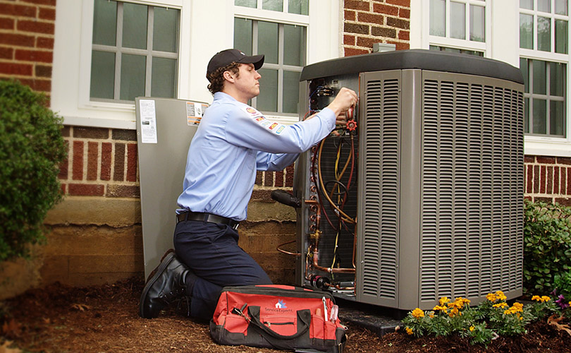 Technician servicing air conditioner in Brampton, Ontario